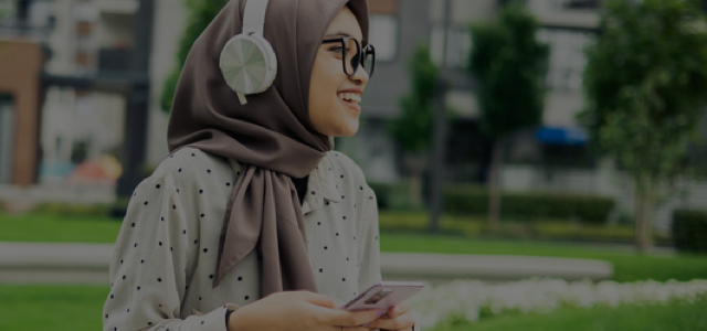 A woman with a head wrap holding her phone