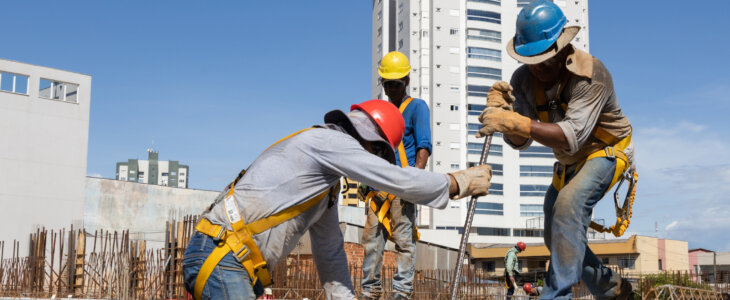 Men from the construction industry, working on the work of a building under construction. Placing slab pieces made with steel and concrete.