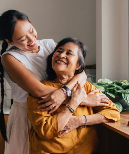 A mother being hugged by her daughter