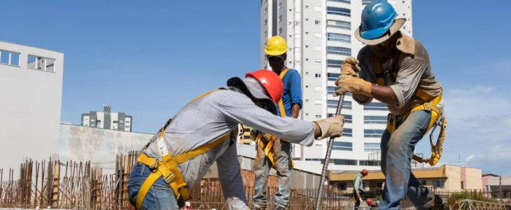 Men from the construction industry, working on the work of a building under construction. Placing slab pieces made with steel and concrete.
